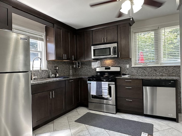 652 Beckman Dr, Kankakee, IL 60901 - kitchen with stainless steel appliances, dark stone counters, a ceiling fan, and backsplash