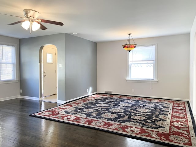 652 Beckman Dr, Kankakee, IL 60901 - unfurnished room featuring arched walkways, plenty of natural light, a ceiling fan, and hardwood / wood-style floors