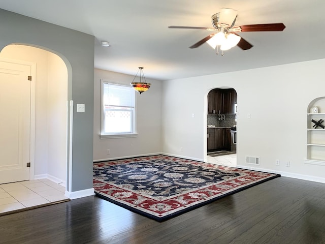 652 Beckman Dr, Kankakee, IL 60901 - spare room with arched walkways, light wood finished floors, and a ceiling fan