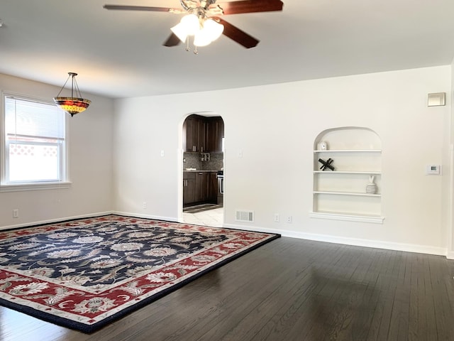 652 Beckman Dr, Kankakee, IL 60901 - unfurnished room with arched walkways, a ceiling fan, light wood-style flooring, and built in shelves