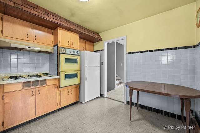 4421 Elmleaf Dr, Mchenry, IL 60051 - kitchen with freestanding refrigerator, multiple ovens, under cabinet range hood, tile walls, and gas stovetop