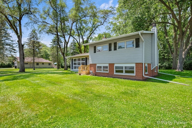 4421 Elmleaf Dr, Mchenry, IL 60051 - rear view of property with a chimney, brick siding, and a lawn