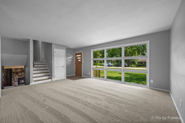 4421 Elmleaf Dr, Mchenry, IL 60051 - unfurnished living room featuring carpet floors, a stone fireplace, and stairway