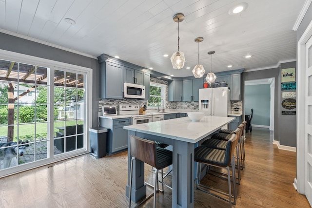 1507 Eton Ln, Naperville, IL 60565 - kitchen featuring white appliances, decorative backsplash, a center island, a kitchen breakfast bar, and recessed lighting