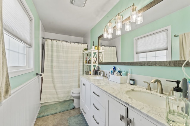 1507 Eton Ln, Naperville, IL 60565 - full bath with double vanity, healthy amount of natural light, tile patterned floors, a shower with curtain, and a wainscoted wall