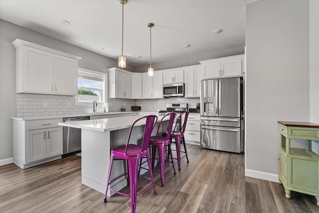 507 Raef Rd, Downs, IL 61736 - kitchen with stainless steel appliances, white cabinetry, a center island, backsplash, and recessed lighting