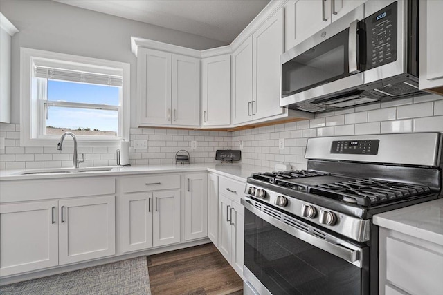 507 Raef Rd, Downs, IL 61736 - kitchen featuring stainless steel appliances, white cabinetry, dark wood finished floors, and backsplash