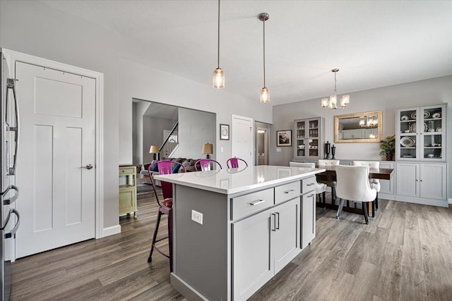 507 Raef Rd, Downs, IL 61736 - kitchen with wood finished floors, a chandelier, light countertops, decorative light fixtures, and a kitchen island