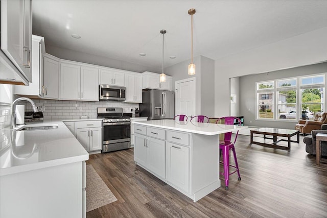 507 Raef Rd, Downs, IL 61736 - kitchen featuring appliances with stainless steel finishes, open floor plan, a kitchen breakfast bar, tasteful backsplash, and light countertops
