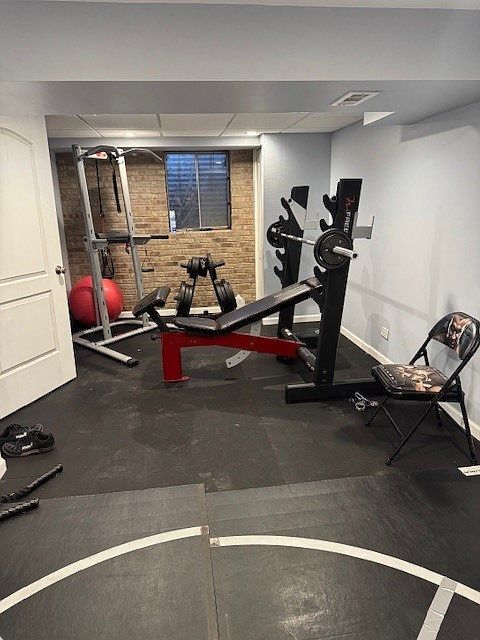 8221 Meadowwood Ave, Woodridge, IL 60517 - workout area featuring baseboards and brick wall