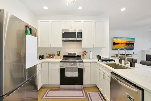 2355 W Congress Pkwy Unit 1, Chicago, IL 60612 - kitchen featuring stainless steel appliances, white cabinetry, recessed lighting, light wood-type flooring, and light stone counters