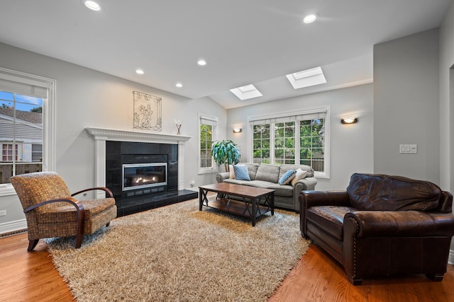 2210 Center Ave, Northbrook, IL 60062 - living room featuring wood finished floors, a skylight, a tiled fireplace, recessed lighting, and lofted ceiling