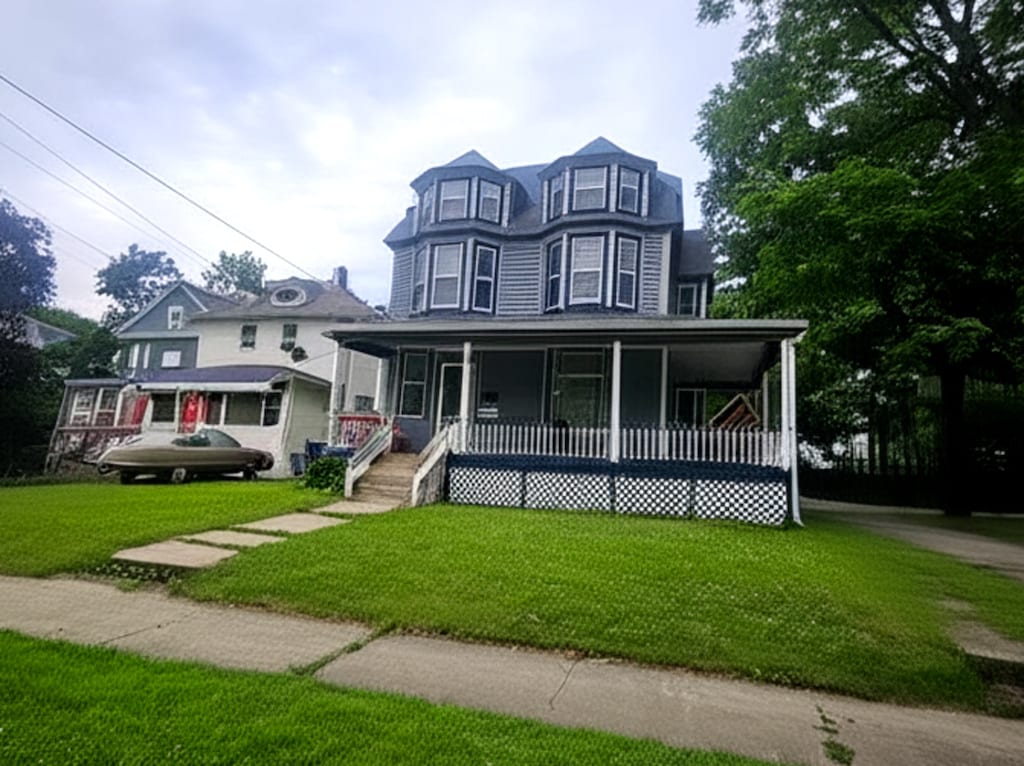 723 N County St, Waukegan, IL 60085 - victorian home featuring covered porch and a front lawn