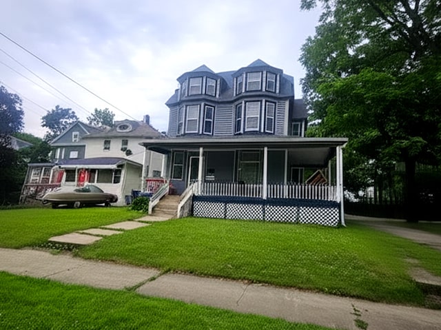 723 N County St, Waukegan, IL 60085 - victorian home featuring covered porch and a front lawn