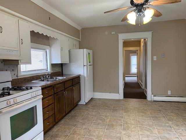 132 S Mchenry Ave, Crystal Lake, IL 60014 - kitchen with white appliances, exhaust hood, baseboard heating, dark countertops, and ceiling fan