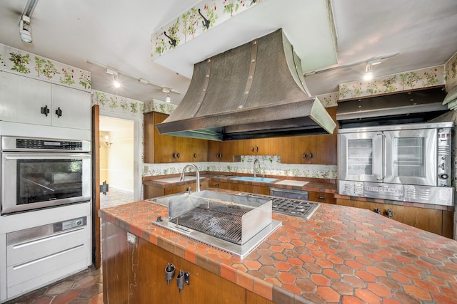 20020 Western Ave, Olympia Fields, IL 60461 - kitchen featuring stainless steel appliances, island range hood, rail lighting, decorative backsplash, and tile counters