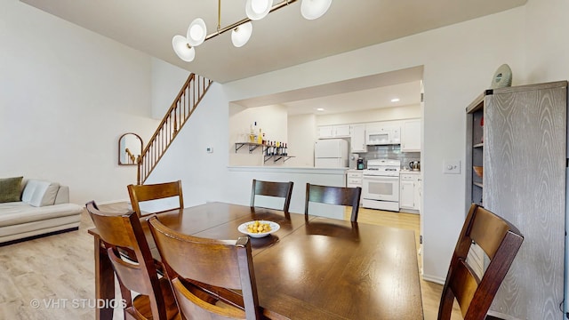 2328 Sedgfield Ct, Schaumburg, IL 60194 - dining area featuring light wood-style floors, stairs, and a chandelier