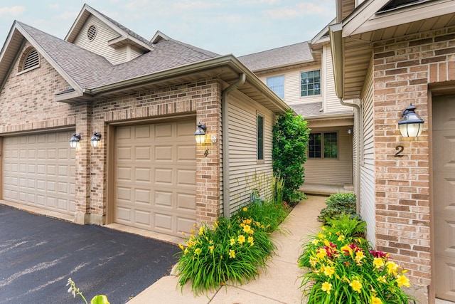 4 Meadow Trl W, Dekalb, IL 60115 - view of property exterior with driveway, brick siding, a garage, and roof with shingles