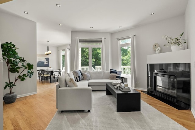 377 Aaron Ln, Bolingbrook, IL 60440 - living room featuring light wood-style floors, a fireplace with flush hearth, recessed lighting, and a chandelier