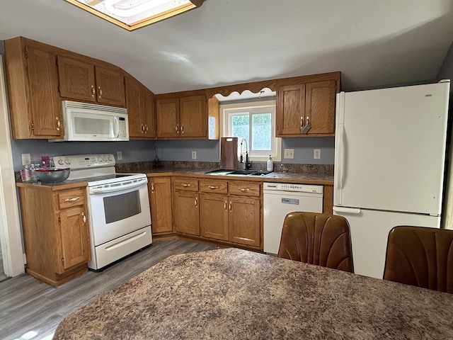 310 E Chippewa St, Dwight, IL 60420 - kitchen featuring white appliances, wood finished floors, brown cabinetry, dark countertops, and lofted ceiling