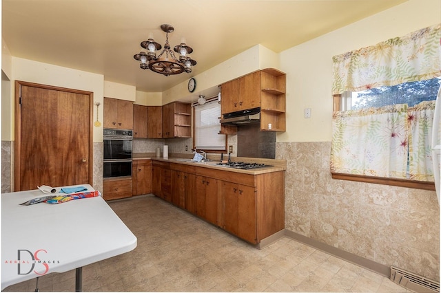 132 New St, Seneca, IL 61360 - kitchen with open shelves, a baseboard radiator, under cabinet range hood, a chandelier, and light floors
