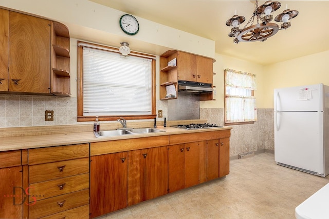 132 New St, Seneca, IL 61360 - kitchen with freestanding refrigerator, open shelves, under cabinet range hood, light countertops, and brown cabinets