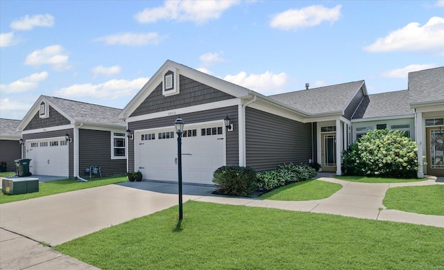3013 E Stillwater Lndg Unit 3013, Urbana, IL 61802 - view of front of home with an attached garage, a front lawn, concrete driveway, and roof with shingles
