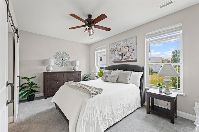 3013 E Stillwater Lndg Unit 3013, Urbana, IL 61802 - bedroom featuring light carpet, a ceiling fan, and a barn door
