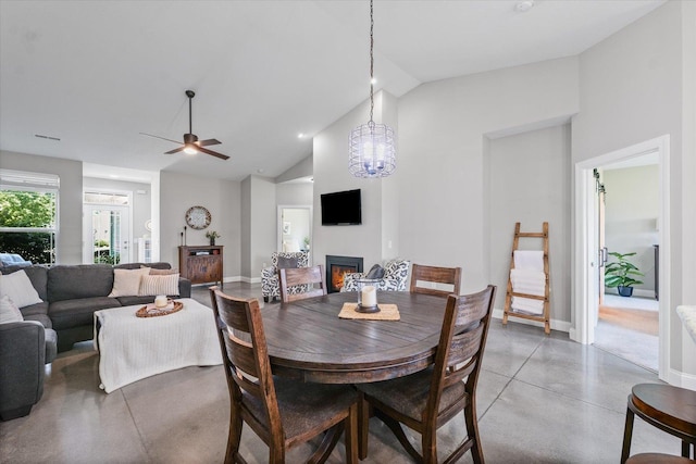 3013 E Stillwater Lndg Unit 3013, Urbana, IL 61802 - dining room with a lit fireplace, concrete flooring, high vaulted ceiling, ceiling fan, and a chandelier