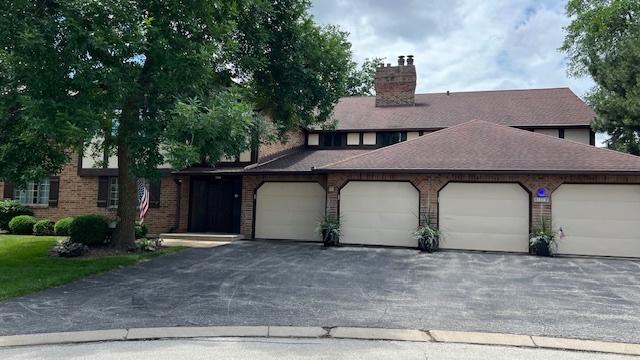 13216 N Country Club Ct Unit 2Aa, Palos Heights, IL 60463 - view of front facade with a chimney, a garage, and driveway