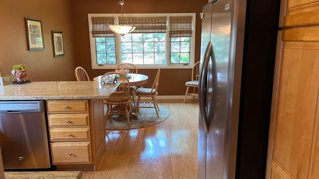 13216 N Country Club Ct Unit 2Aa, Palos Heights, IL 60463 - kitchen with stainless steel appliances, light wood-style flooring, light stone counters, and decorative light fixtures