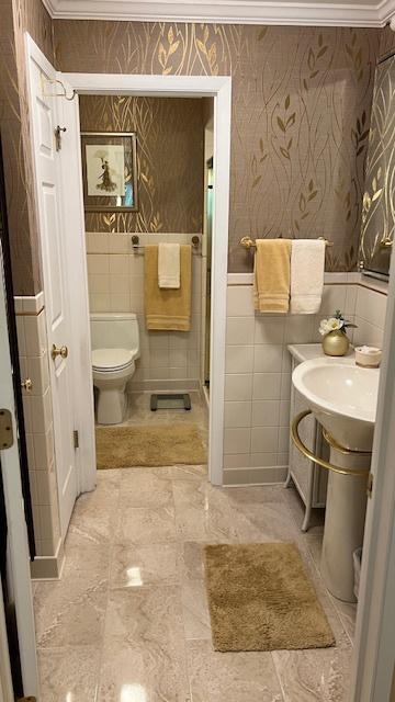 13216 N Country Club Ct Unit 2Aa, Palos Heights, IL 60463 - bathroom with tile walls, ornamental molding, wallpapered walls, and a stall shower