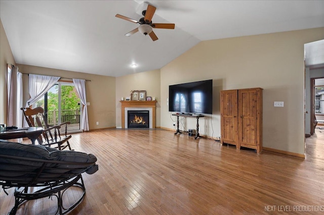 317 Plymouth Ct, Sycamore, IL 60178 - living area featuring a ceiling fan, light wood finished floors, a fireplace with flush hearth, and high vaulted ceiling