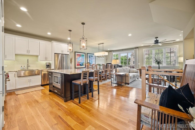 520 Ohio Ave, Saint Charles, IL 60174 - kitchen with stainless steel appliances, open floor plan, white cabinets, light wood-style flooring, and recessed lighting