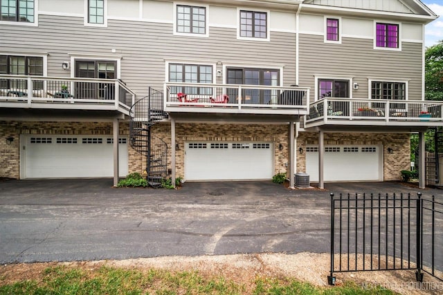 520 Ohio Ave, Saint Charles, IL 60174 - rear view of property featuring a garage, asphalt driveway, brick siding, and stairway