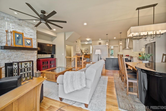 520 Ohio Ave, Saint Charles, IL 60174 - living room featuring a ceiling fan, a stone fireplace, recessed lighting, light wood-type flooring, and a chandelier