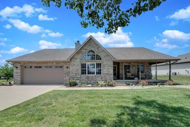 1245 Patriot Way, Bourbonnais, IL 60914 - view of front of home featuring a porch, a garage, brick siding, driveway, and a front lawn