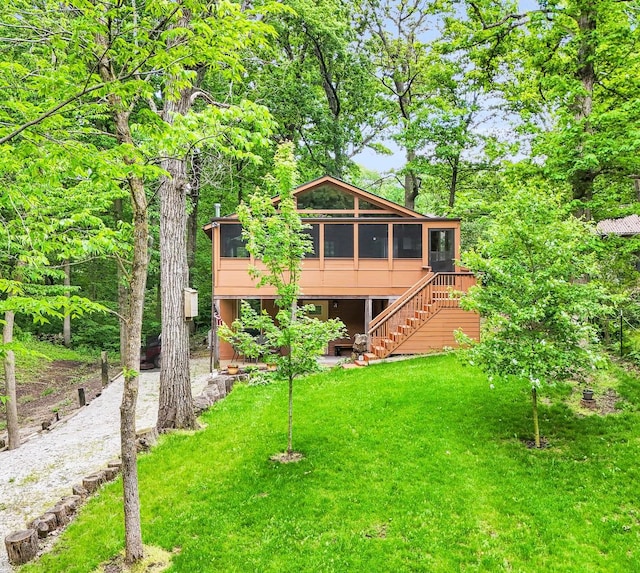131 Shawnee Ln, Loda, IL 60948 - back of property featuring a sunroom, a lawn, and stairway