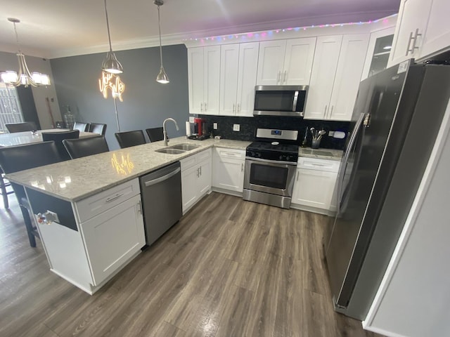 7009 W Crandall Ave, Worth, IL 60482 - kitchen featuring stainless steel appliances, a peninsula, a chandelier, crown molding, and dark wood finished floors