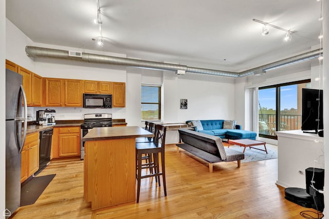 1000 E 53rd St Unit 501, Chicago, IL 60615 - kitchen featuring black appliances, track lighting, a kitchen island, and dark countertops