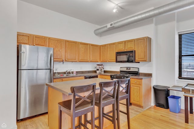 1000 E 53rd St Unit 501, Chicago, IL 60615 - kitchen with appliances with stainless steel finishes, light wood finished floors, dark countertops, a breakfast bar, and a center island