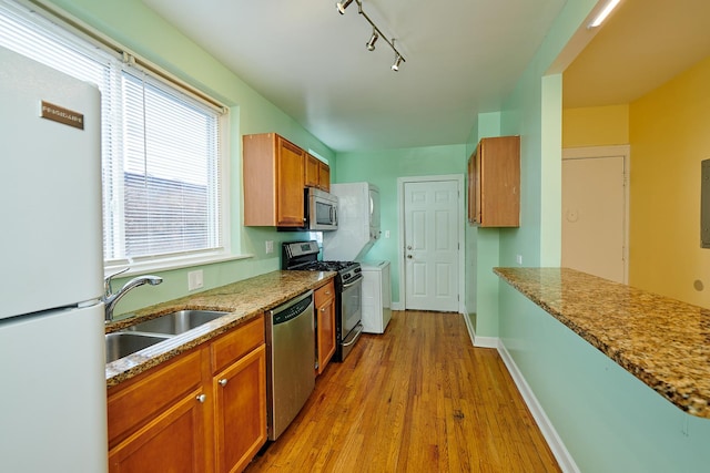 6333 N Francisco Ave Unit 2, Chicago, IL 60659 - kitchen with appliances with stainless steel finishes, light wood-type flooring, brown cabinetry, track lighting, and light stone countertops