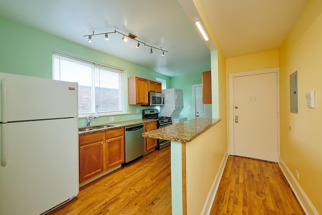 6333 N Francisco Ave Unit 2, Chicago, IL 60659 - kitchen with appliances with stainless steel finishes, light wood-style flooring, electric panel, brown cabinets, and a peninsula