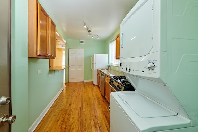 6333 N Francisco Ave Unit 2, Chicago, IL 60659 - kitchen featuring stacked washer and clothes dryer, brown cabinetry, light wood-type flooring, dishwasher, and light countertops