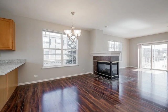 4199 Milford Ln Unit 4199, Aurora, IL 60504 - unfurnished living room featuring a chandelier, dark wood-type flooring, and a tile fireplace