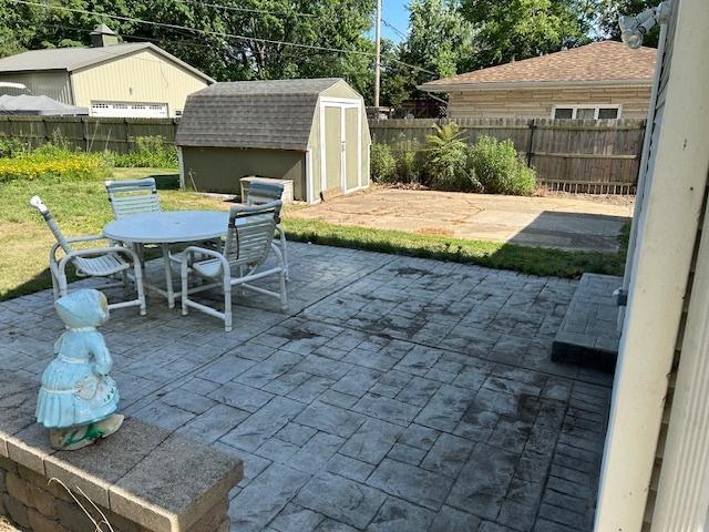 1927 Lakewood Dr, Wilmington, IL 60481 - fenced backyard with a patio, outdoor dining space, and a storage shed