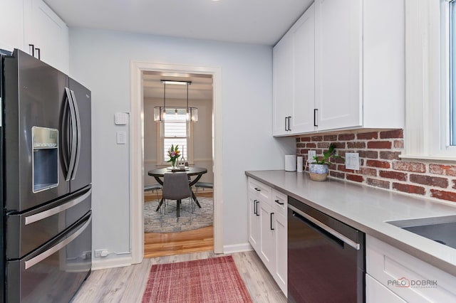 1923 Warren St, Evanston, IL 60202 - kitchen with stainless steel appliances, light wood-type flooring, white cabinets, and decorative backsplash