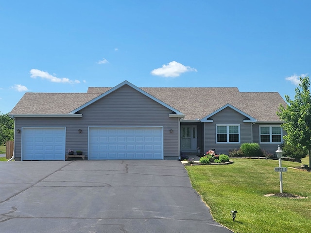 8803 S Rood Rd, Kingston, IL 60145 - view of front facade featuring asphalt driveway, a garage, a front lawn, and roof with shingles