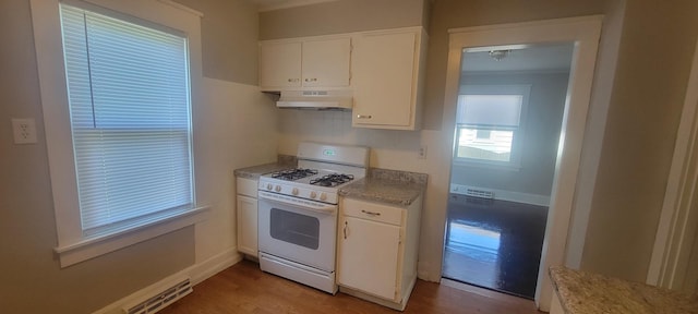 1325 21st Ave, Rockford, IL 61104 - kitchen featuring white gas stove, under cabinet range hood, white cabinets, and wood finished floors