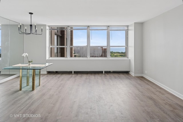655 W Irving Park Rd Unit 2608, Chicago, IL 60613 - unfurnished room featuring a chandelier and wood finished floors